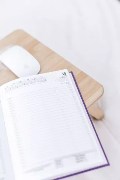 a wooden desk with a mouse and a book